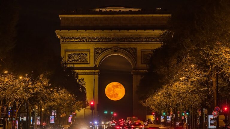 Une photo parfaitement synchronisée capture la pleine lune encadrée par l’Arc de Triomphe