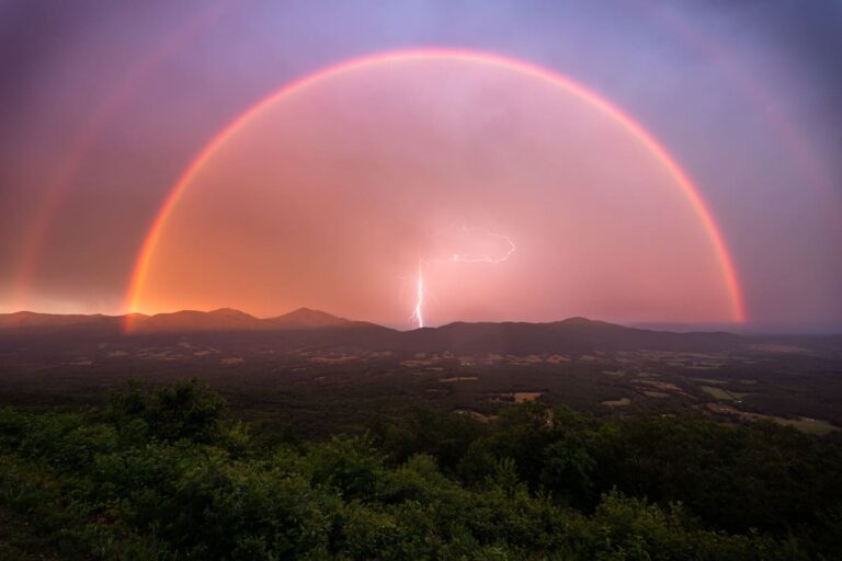 Superbe photo d’un éclair encadré par un double arc-en-ciel